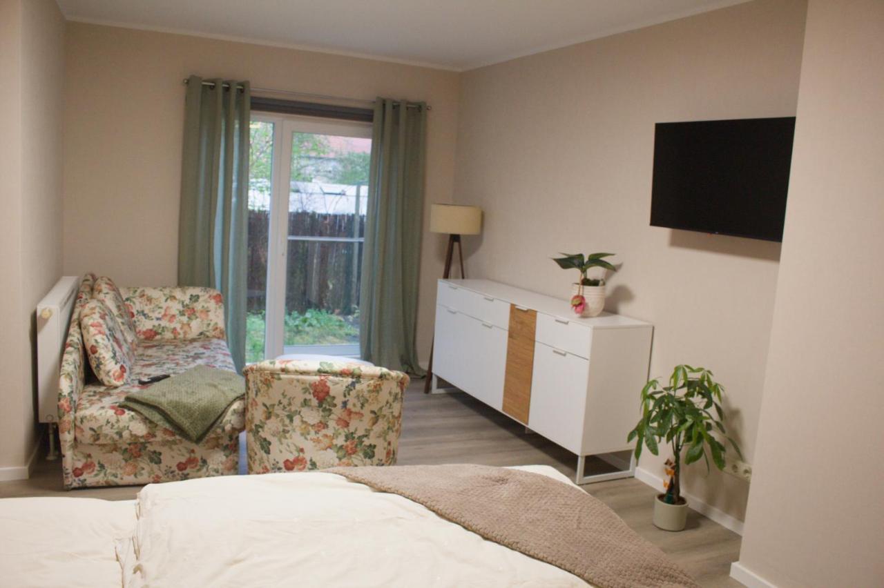 Helles Doppelzimmer mit Sofa, Sessel, Sideboard und Gartentür